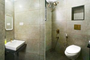 a bathroom with a toilet and a sink and a shower at Hotel O EKAB Hospitality in Mundhwa
