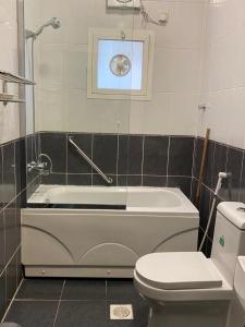 a bathroom with a tub and a toilet and a window at كنده للشقق المخدومة - Kinda Serviced Apartments in Taif +6 photos