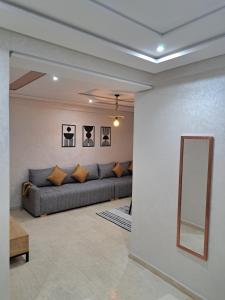 uma sala de estar com um sofá e um espelho em Appartement Au Centre Ville Prés de la Medina em Fez