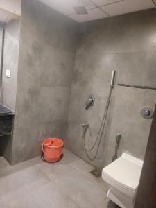 ein Badezimmer mit Dusche, Toilette und Eimer in der Unterkunft Hotel sapphire regency in Vadodara