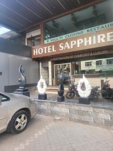 ein Auto, das vor einem Hotel Saphir geparkt ist in der Unterkunft Hotel sapphire regency in Vadodara