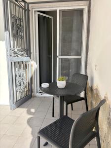 a table and chairs on a balcony with a window at Dolci Momenti in Gragnano