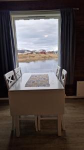 a table and chairs in a room with a window at Jakobselvkaia in Vadsø
