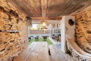 a living room with a stone wall and a couch at Casas da Chica com Piscina, Arouca in Espiunca
