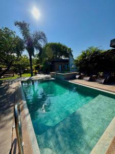 a swimming pool with blue water in a yard at Pousada Águas do Jalapão in Ponte Alta do Norte