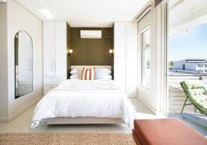een slaapkamer met een bed en een groot raam bij Sonvanger Studio at Andringa Mall Luxury Apartments in Stellenbosch +21 foto's
