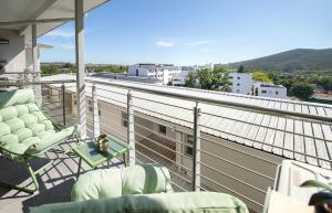 een balkon met stoelen en uitzicht op de stad bij Sonvanger Studio at Andringa Mall Luxury Apartments in Stellenbosch