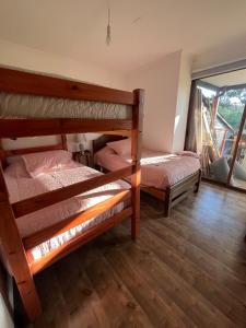 a bedroom with two bunk beds and a window at Maitencillo, amplía y cómoda casa, con piscina y hoy tub in Puchuncaví