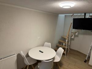 a room with a white table and chairs and a tv at Asiatisches Landhaus Pension in Braunsbedra