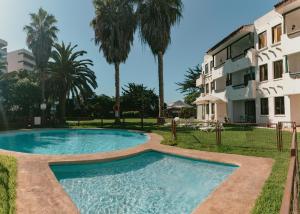a swimming pool in front of a building at Apart Hotel Sendero del Sol in La Serena
