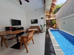 a living room with a swimming pool next to a house at Villa Nala - Uluwatu Nusa Dua in Ungasan
