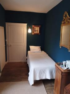 a bedroom with two beds and a blue wall at Chambres d'hôtes Saint Denis in Mézières-sur-Issoire