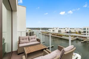 a balcony with two chairs and a table on a building at Sol Marina Riverview with free Parking & SPA additional by Downtown Apartments in Wiślinka