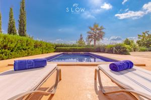 a swimming pool with two chaise lounges next to a swimming pool at Villa Cas Frares by Slow Villas in Consell