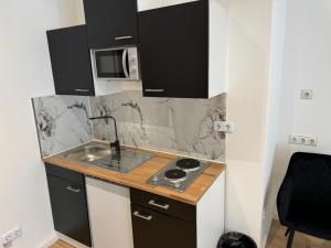 a small kitchen with a sink and a microwave at RRR- Room Rental Rheine in Rheine