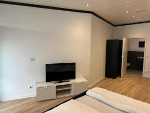a living room with a flat screen tv on a white wall at RRR- Room Rental Rheine in Rheine