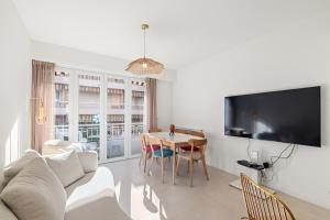 Una sala de estar con un sofá y una mesa con sillas. en 3 pièces Juan les Pins Cosy et Luxueux, en Juan-les-Pins 2 fotos más