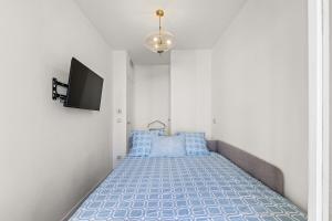 1 dormitorio con 1 cama con almohadas azules y TV en 3 pièces Juan les Pins Cosy et Luxueux, en Juan-les-Pins