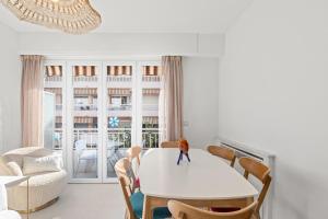 Un comedor con una mesa y sillas blancas. en 3 pièces Juan les Pins Cosy et Luxueux, en Juan-les-Pins