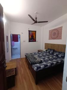 a bedroom with a bed and a ceiling fan at Happy Shiva Cefe & Homestay in Rishīkesh