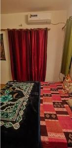 a bedroom with a bed with a quilt on it at Happy Shiva Cefe & Homestay in Rishīkesh