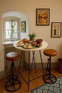 a table with two stools in a room at Vivez un conte de fée dans la pièce ronde d'une tour médiévale in Porrentruy