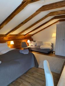een zolderkamer met een bed en een bank bij Chalet Fluh in Schindelberg