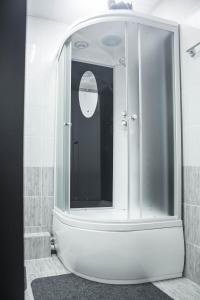 a bathroom with a glass shower with a mirror at Korkem Tau Hotel in Astana
