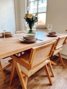 Una mesa de madera con un jarrón de flores encima. en Fewo Sonnenlicht, en Fünfhausen