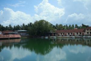 une grande étendue d'eau devant les bâtiments dans l'établissement Vinayaka Tourist Home, à Kozhikode