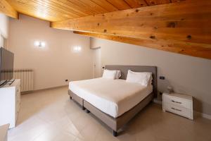 a bedroom with a large bed with a wooden ceiling at NAP Luxury Apartment in Naples