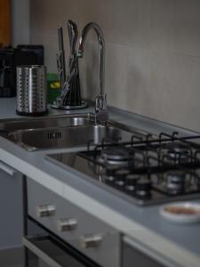 a kitchen counter with a sink and a stove at NAP Luxury Apartment in Naples