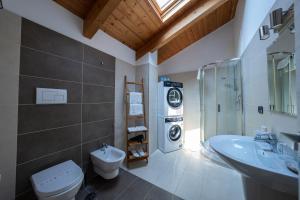 a bathroom with a toilet and a sink and a washing machine at NAP Luxury Apartment in Naples