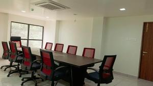 哥印拜陀Hotel Vintage Classic的一间会议室,配有桌子和红色椅子