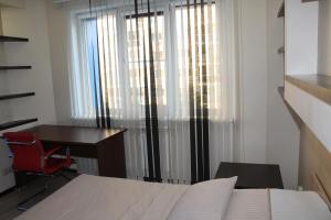ノヴォシビルスクにあるApartments Freedom on Сircus3のベッドルーム1室(デスク、ベッド1台、デスク、窓付)