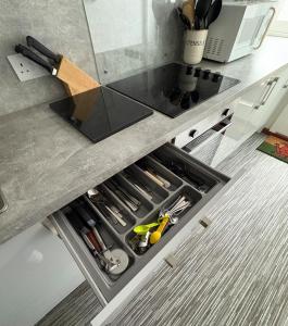 a kitchen counter with a drawer filled with tools at Charming 2 bedroom cottage in Brecon - families and pets welcome! in Brecon