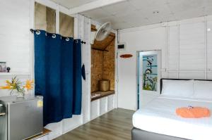 une chambre avec un lit et un rideau bleu dans l'établissement Sunrise House, à Ko Yao Noi 240 autres photos