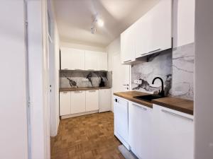 eine weiße Küche mit weißen Schränken und einer Spüle in der Unterkunft Ma Bel Apartments Sarajevo in Sarajevo
