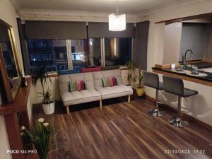 a living room with a couch and a kitchen at Open space studio in Shawlands in Glasgow