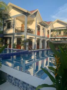 a hotel with a swimming pool in front of a building at Duran Pool & Guesthouse in Sison +22 photos