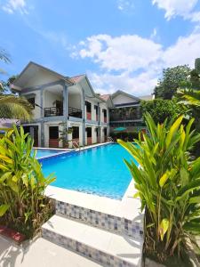 ein Bild eines Swimmingpools vor einem Haus in der Unterkunft Duran Pool & Guesthouse in Sison