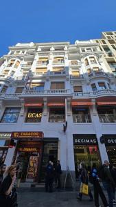a large white building with people standing outside of it at Hostal Lauria in Madrid