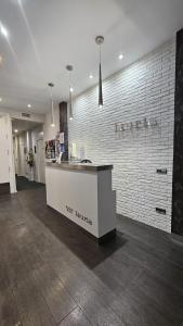 a white counter in a room with a brick wall at Hostal Lauria in Madrid +168 photos