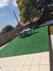 a lawn with chairs and a table on it at Viva Guest House in Trevallyn