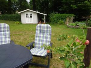 two chairs and a table in a yard with a house at Ferienwohnung Vollmarshausen in Lohfelden +4 photos