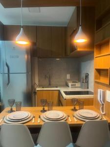 uma cozinha com uma mesa com pratos e taças de vinho em Tamandaré Mar de Campas Flat 218 Carneiros em Tamandaré