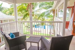 The BrookにあるTropical Escape1511の椅子とテーブルとヤシの木があるポーチ