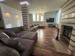 Una sala de estar con un sofá y una chimenea. en Yarema Forest House, en Yarema residence zone