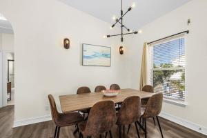 フォートマイヤーズビーチにある241 Miramar Waves- 3BR with Heated Pool homeの木製のテーブルと椅子のあるダイニングルーム