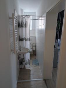 a white bathroom with a sink and a toilet at Wohnen an Seestr in Heidenheim